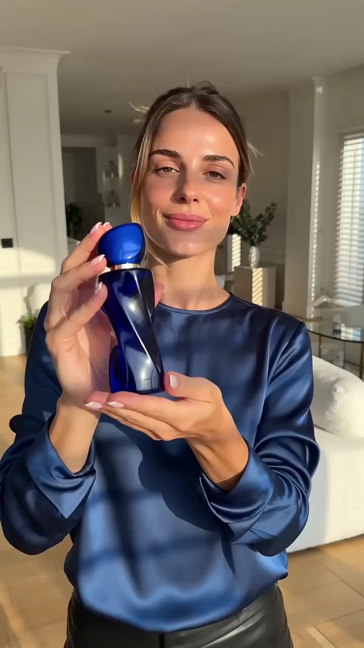 Creator holding a cobalt perfume bottle in a UGC video
